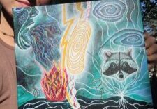 Image of painting by the author. It is a dark blue background with a beam of light anchored into the ground. There is a racoon, tree with lots of branches and roots, and a face blowing wind at the beam of light. Lighting strikes are coming down, a fire blazes, and clouds swirl in the sky.